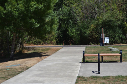 Sidewalk from parking to paved perimeter trail – bench and bike rack